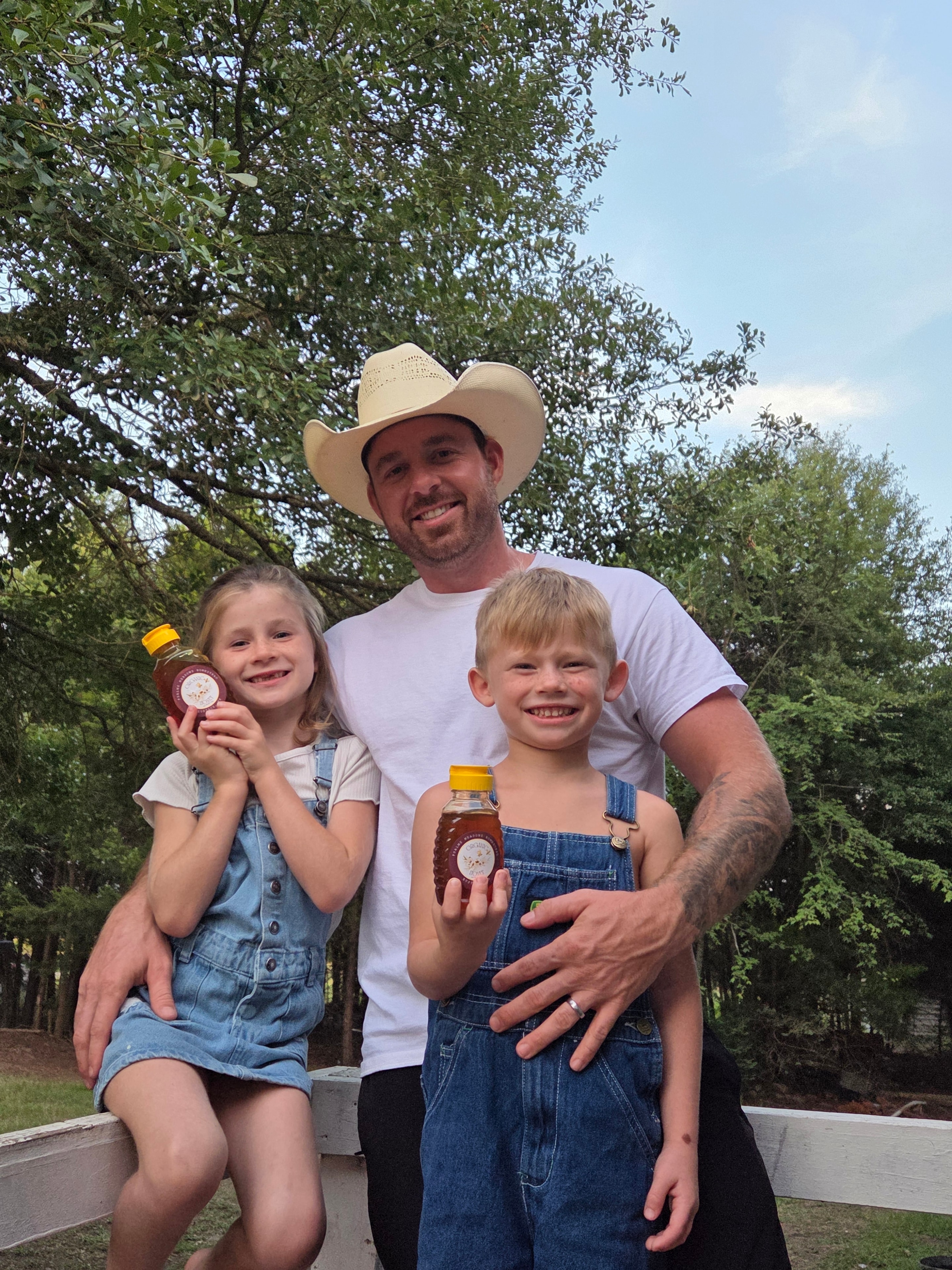 Dad with two kids holding honey jars