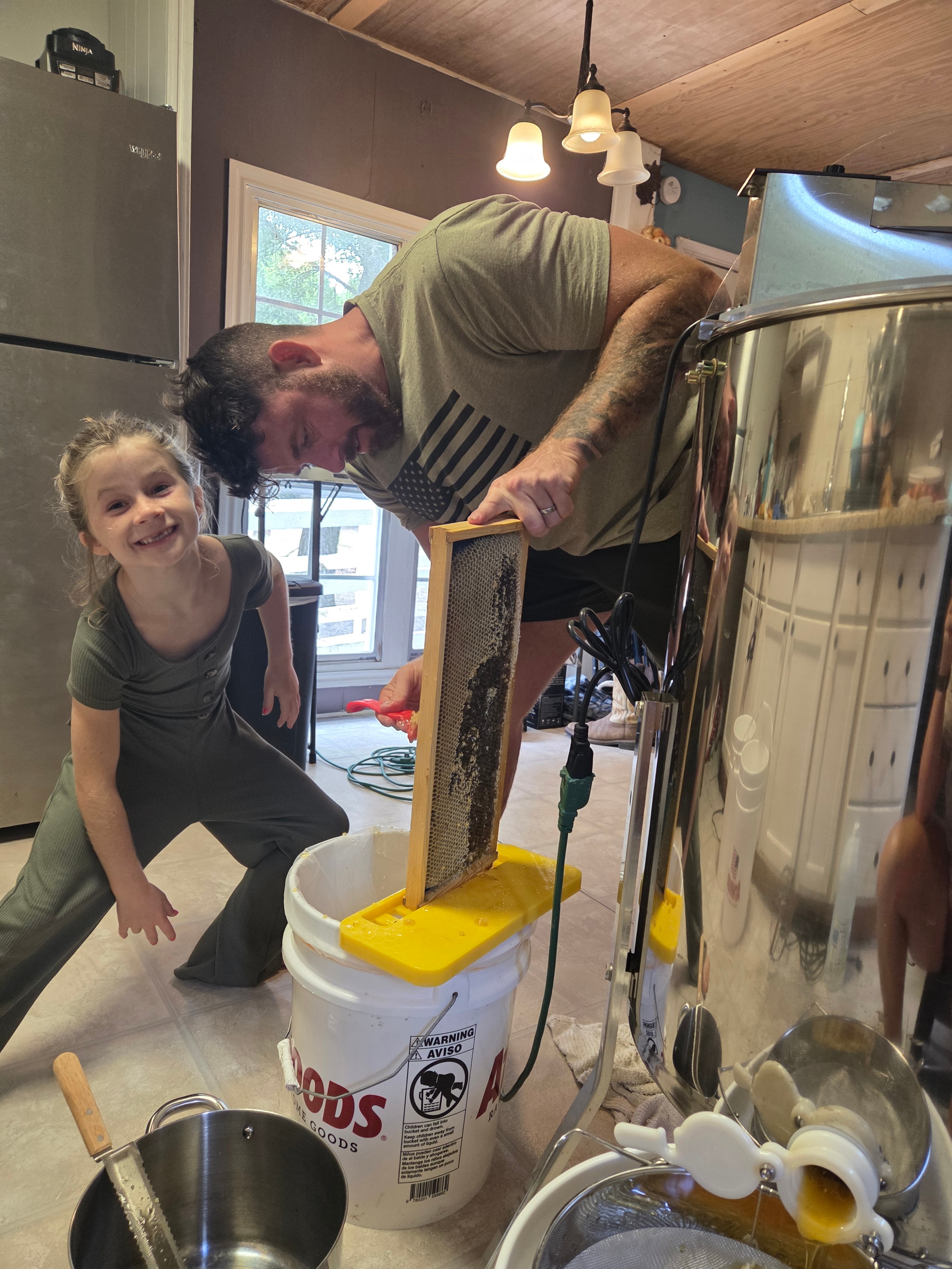 Dad and daughter extracting honey together in the kitchen